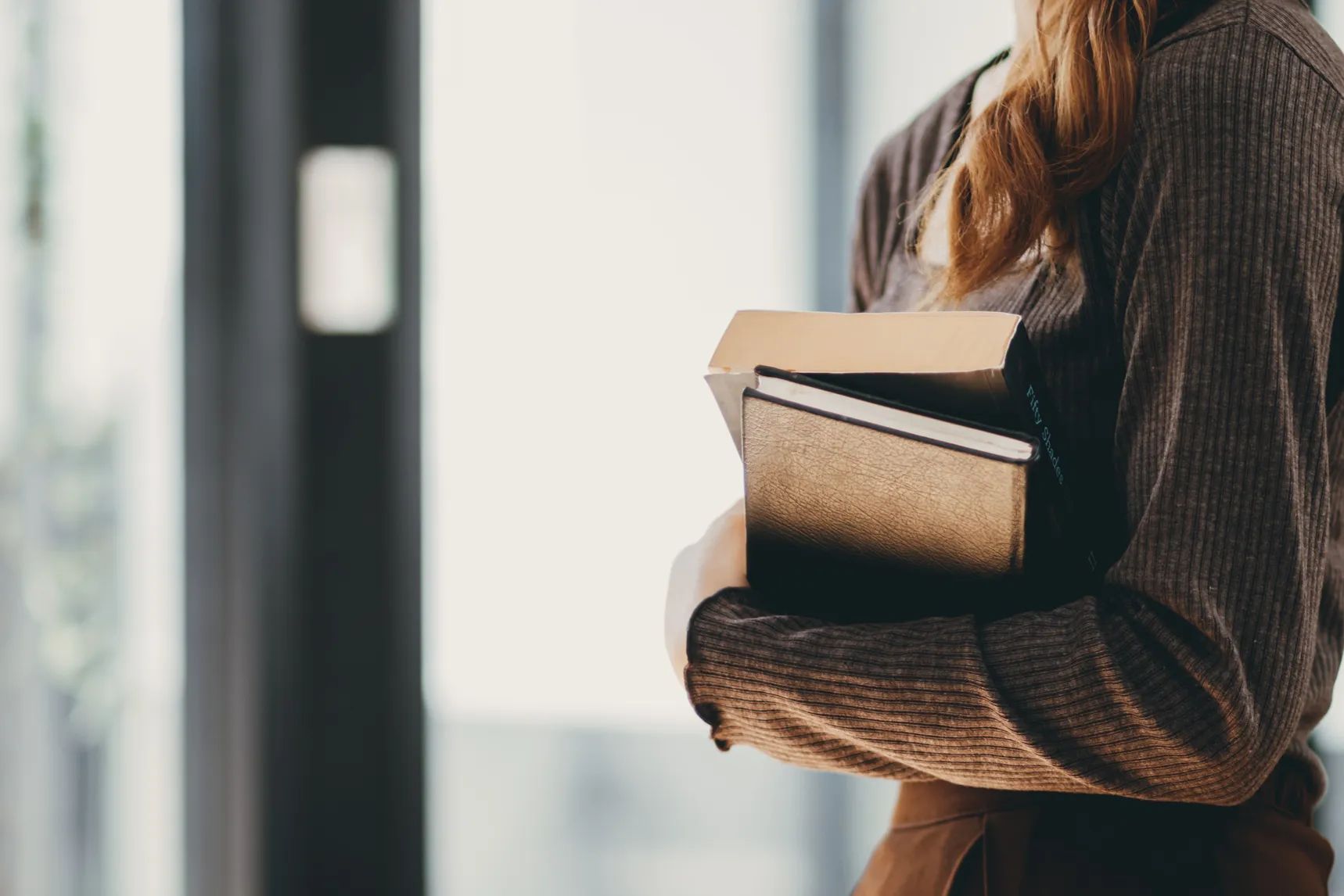 Young woman holding law book in her hand to review and understand law before taking exam to become lawyer. concept of reading books to understand and learn law before taking exam to become lawyer.