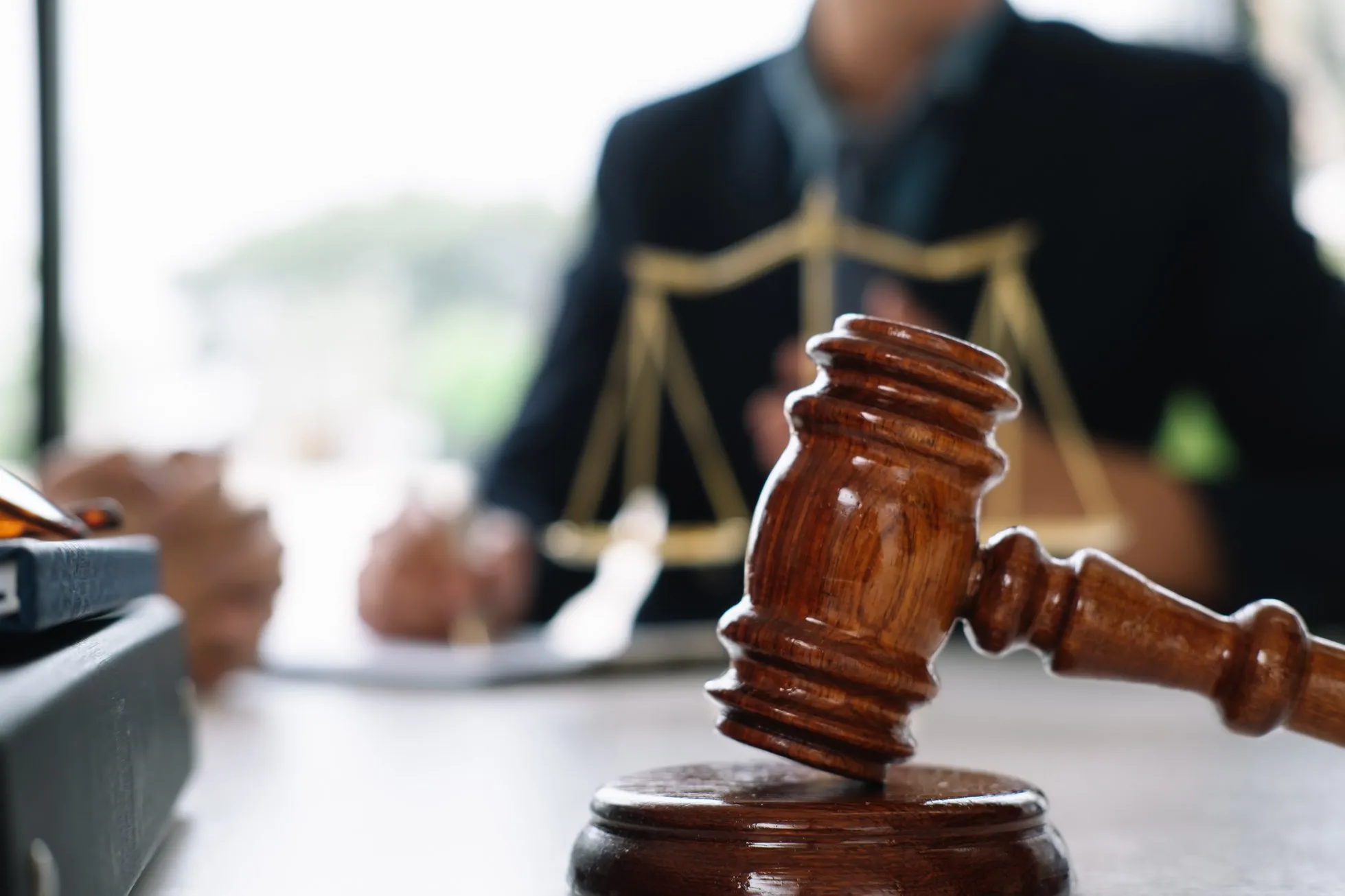 Justice and Law Concept. Gavel on Sounding Block in Hand's Male Judge at a Courtroom, Working with Document Law Books, Report the Case on Table in Modern Office.